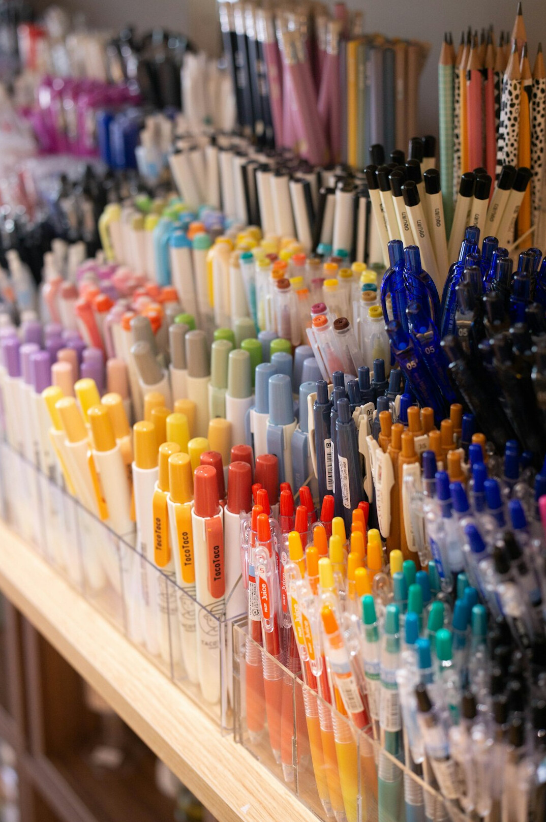 Stack of notebooks and pens on a wooden desk